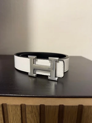 Vitt bälte  - Säljer ett stilrent vitt bälte . Bältet har en klassisk och clean look som lyfter vilken outfit som helst. Perfekt accessoar för dig som gillar exklusiva detaljer.