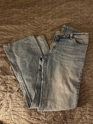 Ljusblå utsvängda jeans från Monki - Säljer ett par ljusblå utsvängda jeans från Monki som är lågmidjade. 