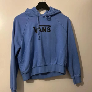 Blå hoodie från Vans med snörning - Säljer en snygg och bekväm blå Vans hoodie. Hoodien är i mycket bra skick och har använts några gånger. Perfekt för både vardagsbruk och avslappnade tillfällen. Materialet är mjukt och skönt, och tröjan har ett klassiskt Vans-tryck på framsidan.
