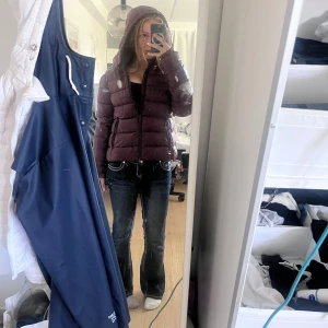 Vinröd pufferjacka från 157 - Säljer en vinröd pufferjacka från 157 i storlek S. Jackan har huva, dragkedja framtill och quiltad design. Materialet är syntet och jackan är vattenavvisande med Bionic Finish Eco. Perfekt för kalla dagar och riktigt snygg färg! Aldrig anväbd med lapparna kvar. Var tyvärr för stor för mig så vill byta mot en i storlek XS