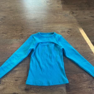 Blå/turkos ish långärmad topp! 💞 - Snygg blå/turkos långärmad topp med cool cut out över bröstet. Aldrig använt och  perfekt för dig som vill sticka ut lite extra med din outfit!! 🫶🏼💞😁
