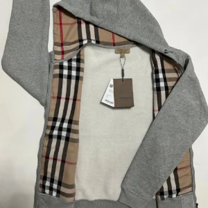 Burberry Zip Hoodie - Säljer en snygg Burberry Zip Hoodie i nästan ny skick 9.5/10✅Tröjan är storlek L men passar M skulle jag vilja säga✅Hör av er vid frågor och funderingar🤩🤝