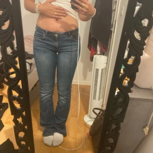 Blå bootcut jeans low rise - Säljer ett par klassiska blå jeans med bootcut-modell och low rise. Jeansen har fem fickor, dragkedja och knapp framtill. Snygg passform som sitter tajt över låren och släpper ut vid vaden. Perfekta till sneakers eller boots.