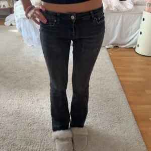 Svarta bootcut jeans från Levis - Super snygga svarta jeans från Levis med bootcut-modell och låg midja. Jeansen har klassiska fem fickor, dragkedja och knapp framtill. Materialet är jeans i bomull med en lätt stretch. Perfekta för dig som gillar en smal passform upptill och utsvängda ben. Se sista bild för små defekter längst ner på Jeansen på baksidan, syns inte vid användning 