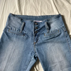 Lågmidjade ljusblå jeans från Just Jeans - Snygga lågmidjade ljusblå jeans från Just Jeans med fyra fickor, dekorativa sömmar och knapp samt gylf framtill. Jeansen har en klassisk passform och är tillverkade i en mjuk bomullsblandning med polyester och lite stretch för extra komfort. Pris är ej hugget i sten. Kontakta för mer frågor o funderingar💕