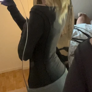 Svart långärmad topp Divided XS - Säljer en svart långärmad topp från Divided i storlek XS. Toppen har en tight passform med bred, något båtformad urringning och detaljer fram till bak på sidorna och långa ärmar. Perfekt att styla med jeans för en clean look.