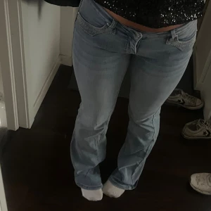 Ljusblå bootcut jeans med detaljer - Säljer ett par ljusblå jeans med bootcut-modell och låg midja. Endast använda 1-2 gånger 
