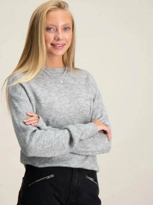 Ljusgrå stickad tröja - En stilren ljusgrå stickad tröja med rund halsringning och långa ärmar. Tröjan har en klassisk, rak passform och är perfekt att matcha med både jeans och kjol. Materialet ser mjukt och bekvämt ut, perfekt för kyligare dagar. 13-14år