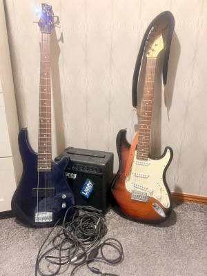 Elgitarr, elbas och förstärkare - Säljer ett musikpaket med en svart elbas, en solbrun elgitarr med vit plektrumskydd och en svart Laney-förstärkare. Paketet inkluderar även kablar och axelband. Perfekt för dig som vill börja spela elgitarr eller elbas.