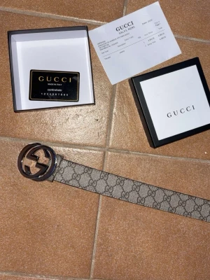 Gucci bälte - Säljer ett klassiskt Gucci bälte med ikoniskt GG-mönster i grått och beige.Perfekt accessoar för att lyfta vilken outfit som helst. Kom privat för mer bilder o info:D man får med allt på bilden