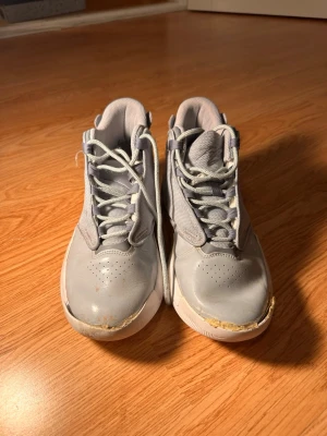 Gråa Jordan sneakers med vita sulor - Snygga gråa Jordan sneakers med vita sulor och klassisk logga på sidan. Skorna har en sportig design med perforerad tå och vadderad plös. Ovandelen är i syntetmaterial och mesh för extra komfort. Perfekta för dig som gillar streetwear och basketstil.