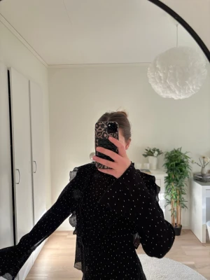 Svart prickig volang blus  - Svart omlottblus med vita prickar och volangdetaljer. Säljer denna då den aldrig kommit till användning. 🩷