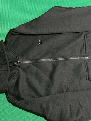 Cdg play hoodie  - Svart hoodie med dragkedja från Comme des Garçons Play. Framsidan har en liten hjärtlogga med ögon på bröstet och baksidan har en stor version av samma logga. Mjuk bomullskänsla och två fickor framtill. Perfekt för en stilren och cool look.