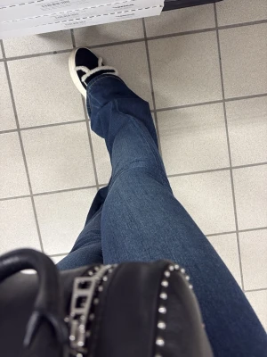 Mörkblå bootcut jeans - Säljer ett par mörkblå bootcut jeans med klassisk femficksdesign. Jeansen har en snygg utsvängd passform som ger en retrovibe och är perfekta till sneakers. Materialet är mjukt denim som sitter bekvämt hela dagen.