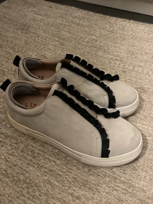 Beiga sneakers med svarta volangdetaljer - Sneakers av skinn, lite användt😅 Från Scorett💞