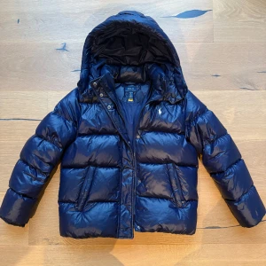 Mörkblå dunjacka från Polo Ralph Lauren - Ralph Lauren puffer jacket, i bra skick. Säljer den eftersom den är för liten. Storlek L 12-14 flicka ganska lik XXS (jag är 154)