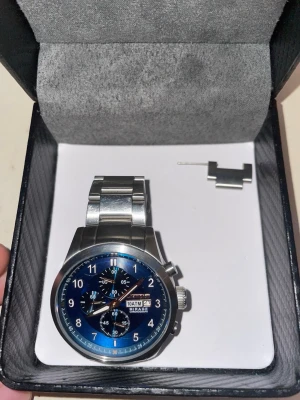 Champion klocka med blå urtavla - Stilren klocka från champion med blå urtavla och silverfärgat armband i metall. Klockan har flera små urtavlor, datumvisning och tydliga siffror. Perfekt accessoar för dig som gillar en klassisk men modern look.