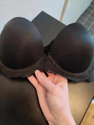 Svart push up bh - Svart push-up bh med spets i storlek 75B. Detta är en modell utan axelband. Aldrig använd då den inte passar.