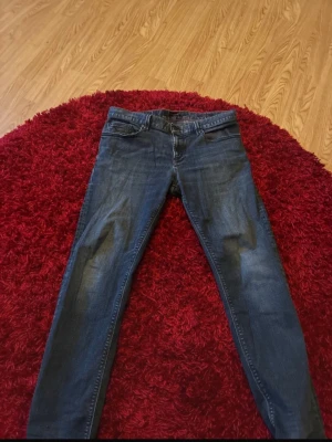 Mörkblå slim fit jeans från Alberto  - Snygga mörkblå slim fit jeans från Alberto med klassiska fem fickor och diskreta slitningar framtill. Jeansen har normal midja, dragkedjegylf och är tillverkade i stretchigt denim för en bekväm passform. Tyvärr ett hål i en av fickorna