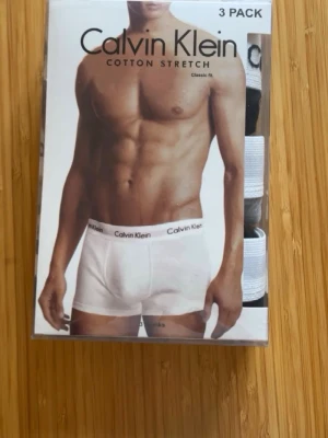 Calvin Klein 3-pack kalsonger - Säljer ett 3-pack Calvin Klein trunks i bomullsstretch. Kalsongerna har klassisk passform och resår med logotyp. Färgerna är vit, svart och grå. Perfekta för dig som vill ha bekväma och stilrena underkläder med snygg design.