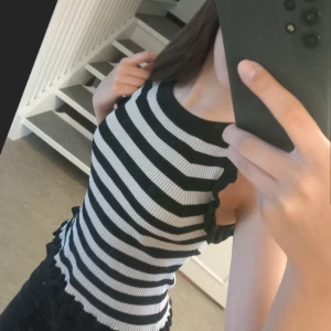 Randig ribbad linnetopp från Lindex - Säljer en svartvit ribbad linnetopp från Lindex. Toppen är ärmlös med volangdetaljer längs kanterna och har en tight passform. Passar perfekt till ett par basic byxor. Priset kan diskuteras.