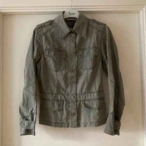 🍒Grön utilityjacka🍒 - 🍒UTILITY🍒Svinsnygg jacka med markerad midja, två bröstfickor med lock och slag på ärmarna och axlarna som detaljer. Kommer i ett 100% bomullstyg.🍒