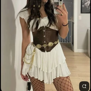 Pirat kostym  - EJ MIN BILD! Säljer en komplett pirat kostym som består av en vit off shoulder klänning som är långärmad, en svart korsett med stretch, pirat hatt, pirat sjal, guldiga små saker man fäster i håret🤗