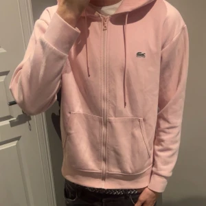 Rosa hoodie från Lacoste - Säljer en ljusrosa/rosa hoodie från Lacoste i storlek M men passar även L kan gå ner i pris så skicka prisförslag😁