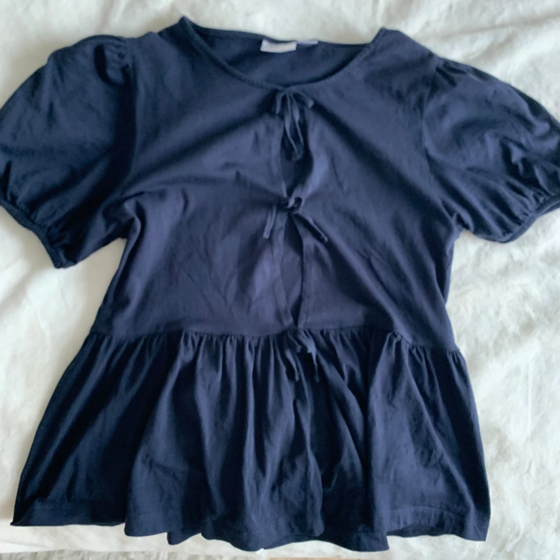 Mörkblå blus med knyt och volang