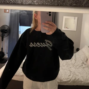 Guess - Svart sweatshirt från Guess med strassdetaljer som bildar loggan på bröstet. Tröjan har en klassisk rund halsringning och långa ärmar. Perfekt för dig som vill ha en stilren men ändå extra look.