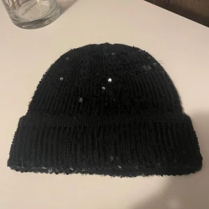 Svart mössa med paljetter - Svart mössa med paljetter, använd 1 gång.