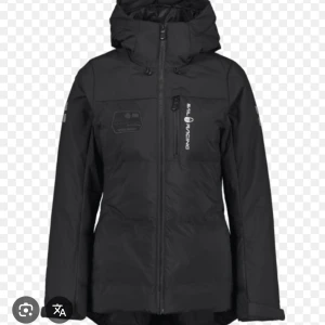 Svart pufferjacka från Sail Racing - Svart pufferjacka från Sail Racing med huva och dragkedja framtill. Jackan har logotyp på bröstet och ärmarna, samt praktiska fickor. Perfekt för kalla dagar och har en snygg, sportig look. Passformen är normal och jackan är tillverkad i syntetmaterial. Jätte fin jacka som ny köpt förra vintern, säljer pgr av har blivit för liten på mig.