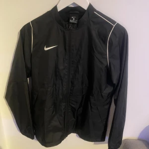 Svart vindjacka från Nike - Säljer en svart vindjacka från Nike i ett väldigt bra skick. Jackan är köpt i en JD affär i England. 