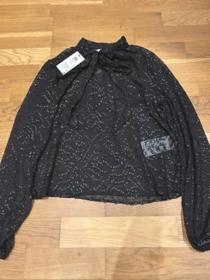 JDY Blus - Svart, skimrig, genomskinlig blus från JDY. Storlek S. Endast testat den en gång och prislappen sitter kvar, Nypris 399kr