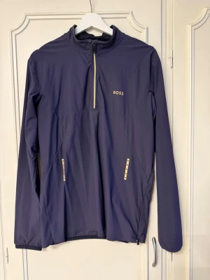 Mörkblå tröja i tunt material från BOSS - Snygg tunn mörkblå tröja från BOSS i storlek S. Tröjan har använts några gånger men har inga skador eller fläckar!