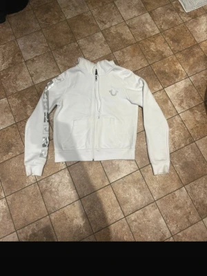 true religion hoodie - true religion hoodie med glittrigt märke på bröstet samt på ena armen. tröjan är köpt i usa och är använd fåtal gånger så som ny. nypris 119 dollar men säljer för 900kr. storlek S. lappen finns kvar men sitter ej på tröjan. pris kan diskuteras!
