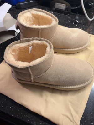 Helt nya Beige UGGs - Säljer ett par klassiska beige UGGs i storlek 39 som är helt oanvända och nya. Priset kan diskuteras så skicka gärna bud💞