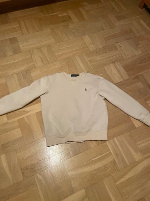 Beige sweatshirt från Polo Ralph Lauren - Produkten är nästan ny. Har använts cirka 3-4 gånger. Säljes då den är för liten. Storleken är M men passformen är snarare XS-S