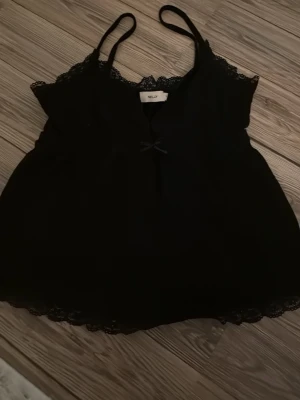 Svart spetslinnetopp - Jättesöt svart linnetopp från Nelly i storlek XS. 
