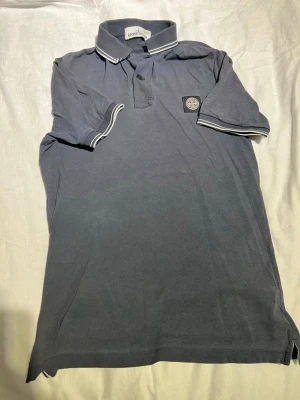 Stone Island Mörkgrå piké - Mörkgrå piké i storlek i storlek S slim fit. Inprencip ny, dock en liten fläck på lappen. 