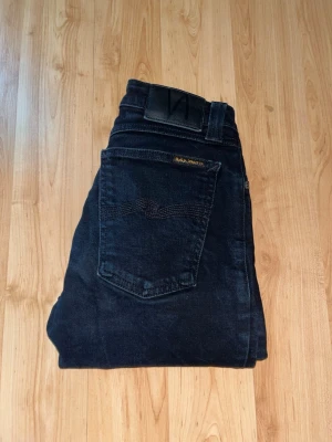 Nudie Jeans - Säljer ett par svarta jeans från Nudie Jeans, modell Skinny Lin. Midja 29cm, längd 102cm. JAG SKICKAR EJ FLER BILDER NÄR JAG BÄR JEANSEN! för bättre inblick i passformen rekommenderar jag att googla på modellnamnet. För storleksguide kolla måtten noggrant då jeansen alltid kan vara uppsydda heller krympta och jag ej tar emot returer :) s5,4