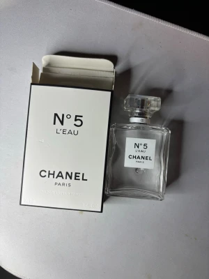 Chanel N°5 L'Eau 50ml - Chanel N°5 L'Eau i 50ml flaska. En ikonisk parfym från Paris, perfekt för dig som vill ha en klassisk och stilren doftupplevelse. Vaporisateur spray för enkel applicering.