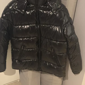 Svart Moncler pufferjacka med huva - Säljer  en svart, glansig pufferjacka från Moncler . Perfekt för kalla dagar byten är även möjligt