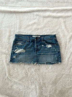 Abercrombie & fitch lågmidjad kjol - En jeanskjol från Abercrombie & fitch i storlek W31, vilket motsvarar en L. Rakt över midjemått: ca 43cm. Jag fraktar inom 24h. Se liknande plagg i min profil!