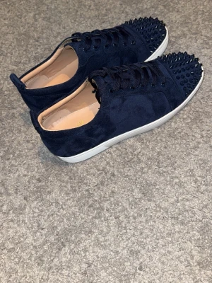 Marinblåa mocka skor med röd undersida -  Säljer nu dessa tvär feta skor som är gjorda av mocka med en röd undersida. Skorna är helt nya och är perfekta för dig som vill ha en stilren outfit.