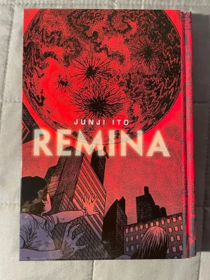 Junji Ito - Remina - Remina är en skrämmande manga med intensivt rödsvart omslag, där en mystisk planet hotar mänskligheten. Perfekt för dig som gillar sci-fi, skräck och mörka berättelser med unika illustrationer. En riktig nagelbitare från Junji Ito som garanterat fångar unga vuxnas intresse.