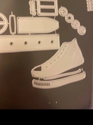 Stora Dies 2 st tomtens bälte och en skridsko för kortmakeri /scrapbooking  - Bilderna visar olika metallstansar för pyssel, bland annat en sko, bälte och knappar. Ingen väst syns på bilderna.