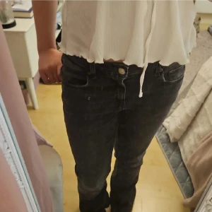 Svarta bootcut jeans från Gina Tricot, stl 152 - Snygga svarta/mörk gråa jeans från Gina Tricot i storlek 152. Jeansen har klassisk femficksdesign, dragkedja och knapp framtill samt bootcut ben. Köpta för runt 150 kr på Gina tricot, använda få gånger men i mycket bra skick förutom en liten vit fläck på baksidan som knappt syns och troligtvis går att tvätta bort. Säljs då de inte kommer till användning längre! Slutsålda online!