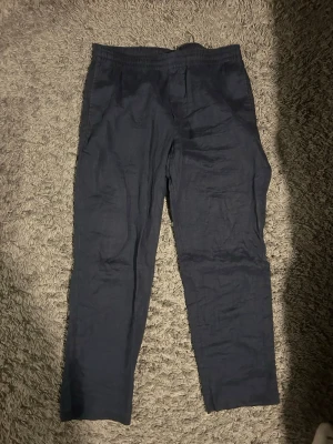 Mörkblå linnebyxor - Snygga mörkblå linnebyxor med avslappnad passform och resår i midjan. Perfekta för dig som gillar en chill och stilren look. Materialet är linne vilket gör dem luftiga och sköna att bära. Passar till sneakers eller sandaler. Från hm 