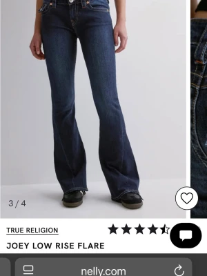 True Religion Joey Low Rise Flare Jeans - Snygga mörkblå jeans från True Religion med låg midja och utställda ben. Modellen Joey Low Rise Flare har klassiska fickor med dekorativa sömmar och knappar bak.❗️TRYCK INTE PÅ KÖP SKRIV INNAN❗️